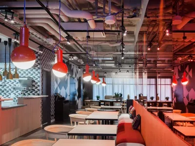 Modern industrial restaurant interior featuring exposed metal and geometric patterns.