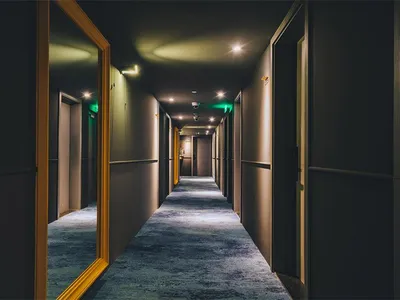 現代酒店內的長走廊，鋪設地毯並搭配嵌入式照明。