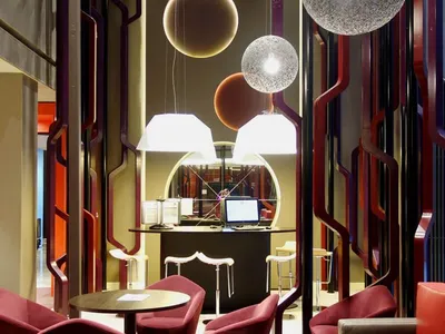 A modern hotel lounge featuring unique lighting fixtures and contemporary seating arrangements.