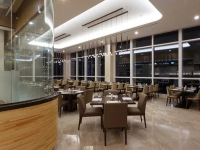 A stylish, modern restaurant interior featuring marble flooring and contemporary decor.