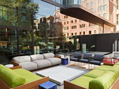 Modern outdoor lounge area with sofas, chairs, and tables.