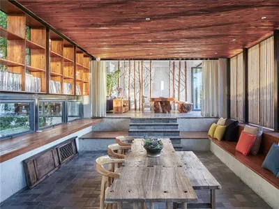 Industriell gestalteter Wohnbereich mit Holz-Einrichtung und offener Raumstruktur.