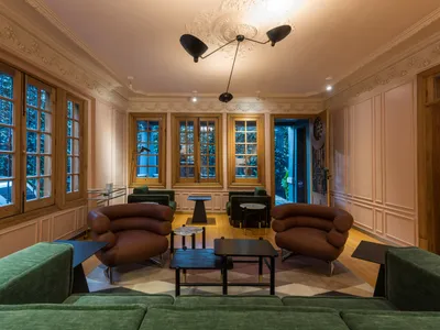 Modern lounge area with leather seating, marble tables, and wood accents