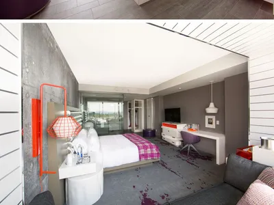 A modern hotel suite featuring a glass-enclosed shower and concrete walls with a leather ottoman and hexagonal tiles