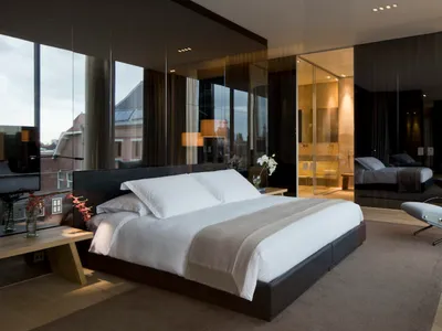 A modern minimalist bedroom with dark wood and glass elements.