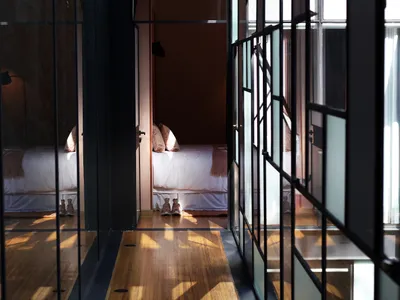 Minimalist bedroom with wooden floor and glass walls