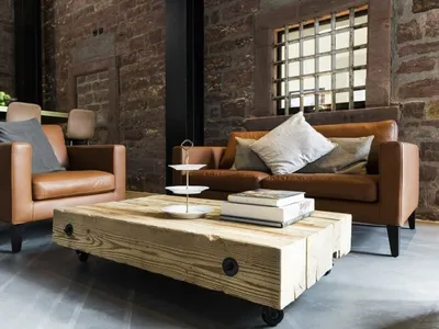A cozy industrial living room with leather furniture, wooden coffee table, and brick walls
