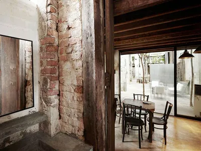Industrial-style restaurant interior with brick walls, concrete floor, and wooden elements