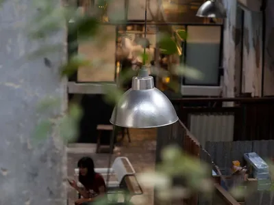 Industrial-style restaurant with metallic pendant lights hanging from ceiling.