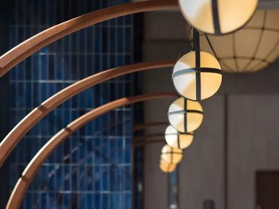 Modern restaurant interior with wooden arches, glass pendant lights, and concrete walls.