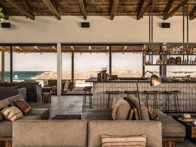 Industrial restaurant interior with concrete walls, wooden tables, and metal accents.