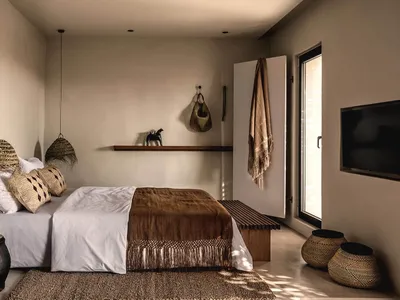 Bedroom featuring minimalist design with natural fiber textiles, wooden elements, and earthy tones.