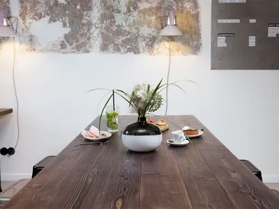 A wooden table adorned with flowers and food in a cafe setting.