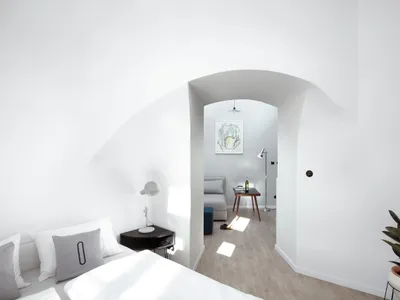 Minimalist bedroom featuring a wood floor and white walls.