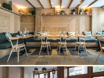 A modern restaurant interior with wooden furnishings and plant decor.