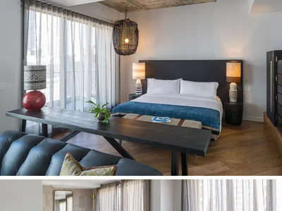 A modern bedroom with a wooden bed, marble accents, and large windows.