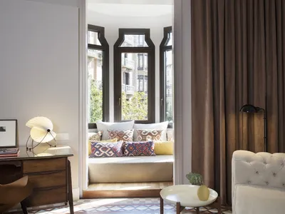 A cozy living room with a white tufted sofa, fabric cushions, and a glass coffee table.