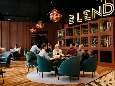People sitting at a table in a modern restaurant bar with contemporary lighting and seating.