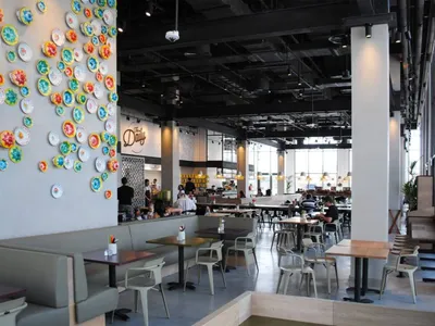 A modern restaurant interior featuring concrete, wood, and metal materials.