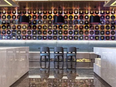 View of a modern restaurant interior featuring mixed materials like glass, metal, and wood.