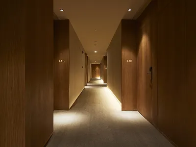A modern hotel corridor with wood paneling.