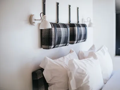 A modern bedroom with a black and white checkered headboard and white bedding.