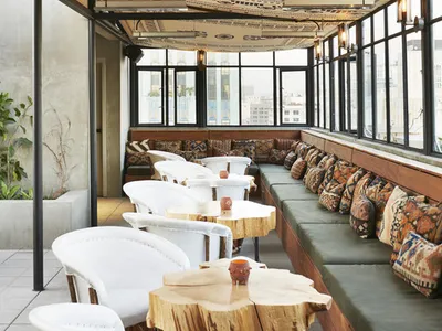 Modern cafe interior featuring minimalist wood tables, concrete flooring, and textured textiles