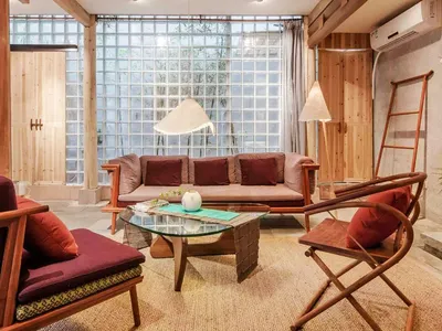 A cozy living room with wooden furniture and glass windows.