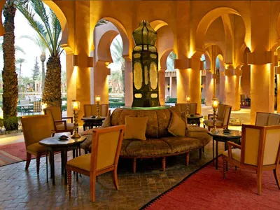 An elegant modern hotel lobby with wooden furniture and fixtures, illuminated by warm lights.