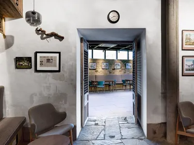 Concrete wall and floor of a cafe interior with framed artwork on the walls.