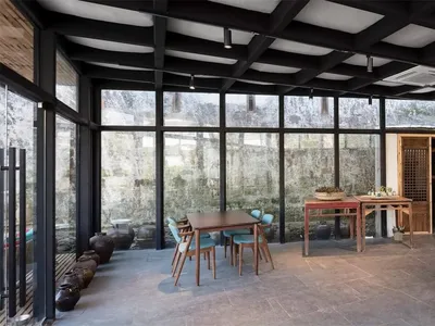 A spacious, industrial-themed restaurant with metal flooring and large glass windows.