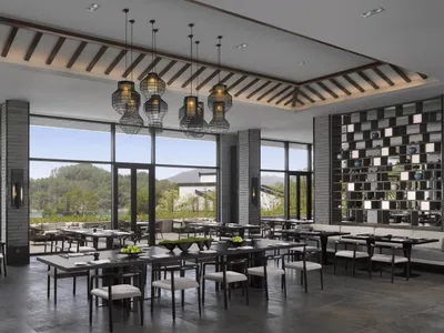 A spacious, modern restaurant interior with large windows, contemporary furniture, and minimalist decor.