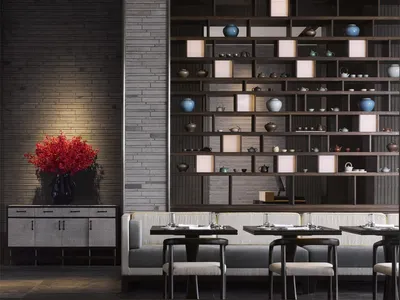 A modern restaurant interior with a long wooden bench, white cushions, and a large wooden bookshelf filled with tea sets