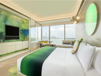 Modern hotel suite featuring a glass wall overlooking a cityscape.
