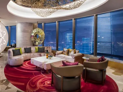 Modern hotel suite featuring marble, glass, and fabric materials.