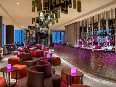 A modern restaurant bar with contemporary design elements and illuminated seating areas.