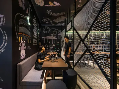 A modern restaurant interior with black walls and a chalkboard wall