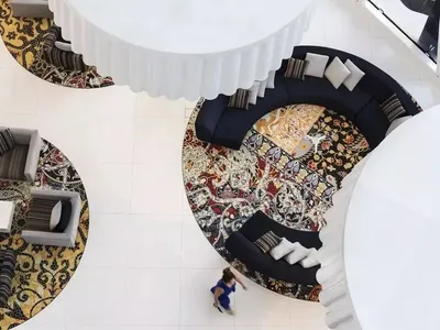 Modern hotel reception area featuring carpet and cushions