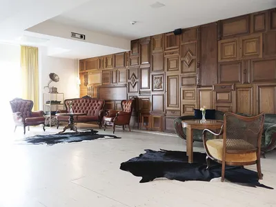 A modern industrial living room with wooden walls and furniture.