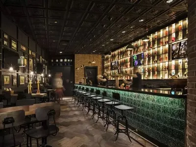 Industrial-themed restaurant or bar interior with exposed brick walls, wooden floors, and metal decor.