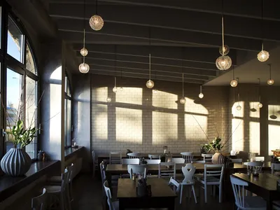 A modern restaurant interior with brick walls and wooden tables.