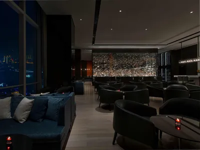 現代酒店酒吧，擺放藍色布面沙發與黑色座椅。
