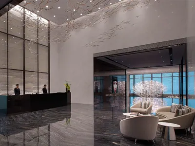 A modern hotel lobby with a glass, marble, and concrete design.