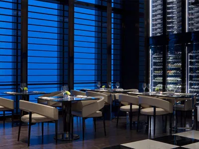 Modern restaurant interior with glass walls and metal accents, showcasing sleek and contemporary design features.