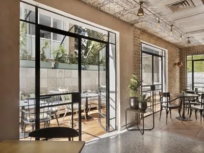 Cafe interior featuring brick walls and concrete flooring with seating arrangements.