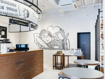 A modern coffee shop interior with exposed brick walls and laminate flooring.