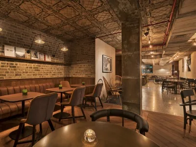 工業風餐廳，擁有磚牆、皮革卡座和木製餐桌。