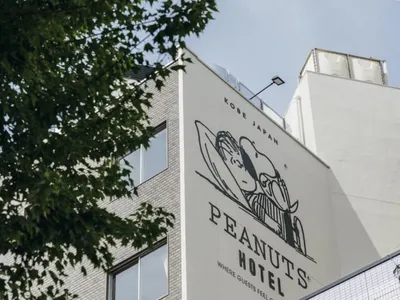 酒店建築外觀採用磚塊與混凝土材質，側面繪有大型花生漫畫角色壁畫。