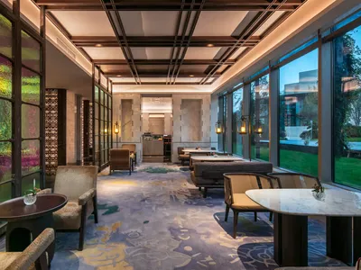 現代奢華的餐廳室內，配有優雅座椅、大理石餐桌與彩繪玻璃窗。