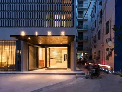 A modern glass exterior of a hotel building at dusk.